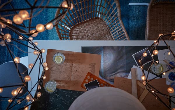 Link to IDEA blog 'A stargazing get-together' - image of table covered with astronomy paraphernalia, surrounded by wicker chairs with LED string lights above.