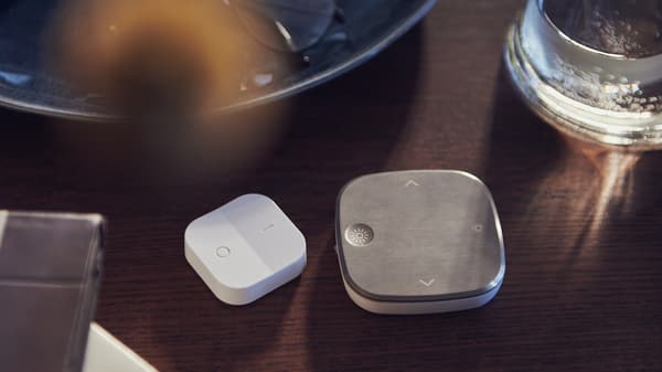 Link to 'Light up your life: lighting design for a smarter home' - image of a white TRÅDFRI wireless dimmer and a stainless steel STYRBAR remote control on a table.