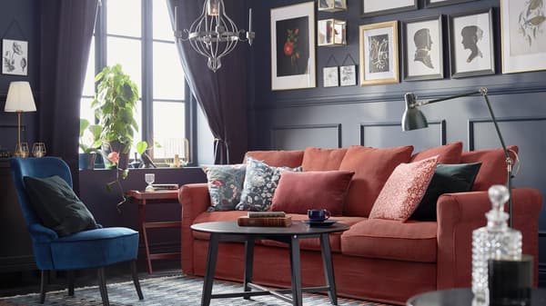 Link to 'Putting the spotlight on accessories' - image of a a dark-panelled, traditionally styled room with framed art and a red sofa.