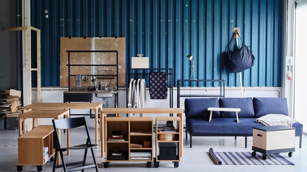 Link to 'RÅVAROR collection' - image of a variety of furniture set against a blue zinc plate wall.