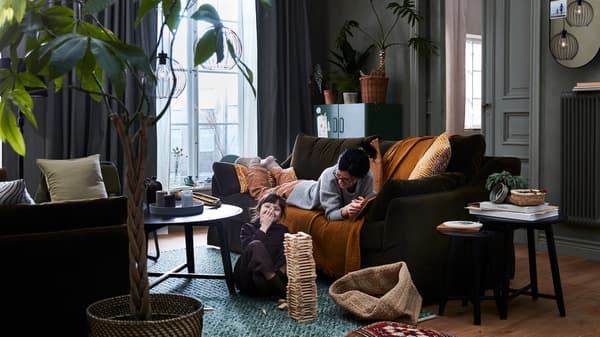 Link to 'Turn up the warmth with easy updates' - image of a mother and child playing in a living room with fall living room décor.