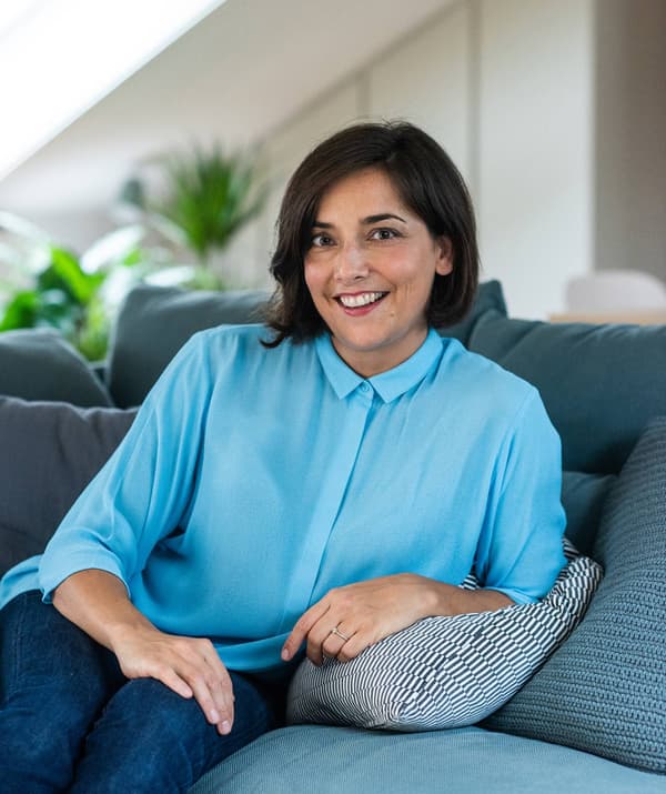 Lisa Casali che sorride ed è seduta su un divano.
