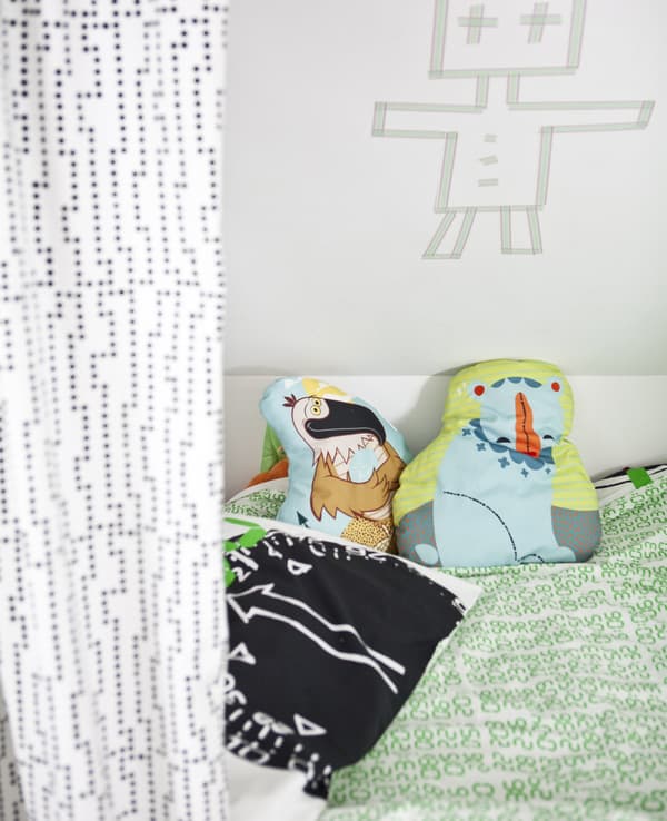 Lit avec linge de lit et coussins colorés.