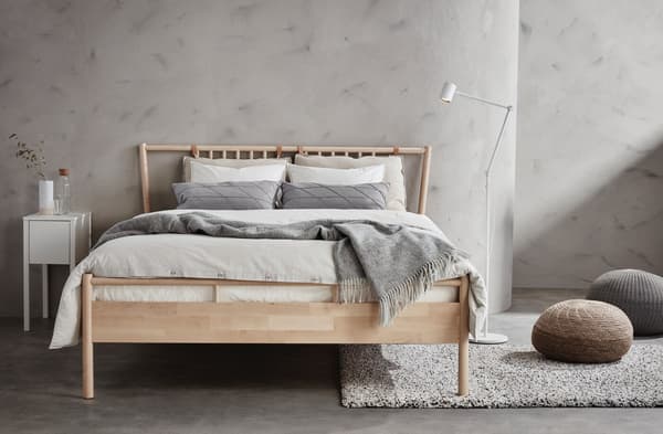 Lit en bois deux places dans une chambre couleur grise.