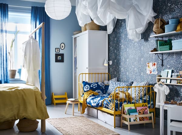 Lit évolutif MINNEN jaune dans une chambre partagée peinte en bleu.