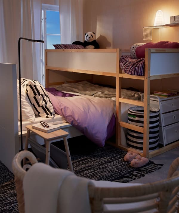 Lit haut pour enfant placé perpendiculairement au lit des parents.