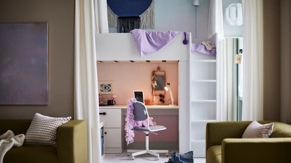Lit mezzanine SMÅSTAD blanc avec un bureau devant lequel se trouve une chaise pivotante ÖRFJÄLL avec un boa en plumes posé sur le dossier.