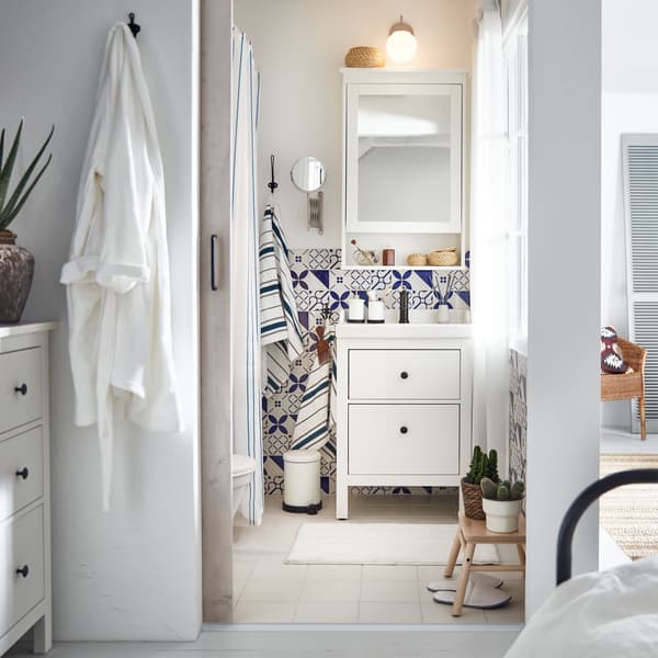 Lite, lyst og luftig bad med blåmønstrede fliser, HEMNES/RÄTTVIKEN servantskap og veggskap med speil.