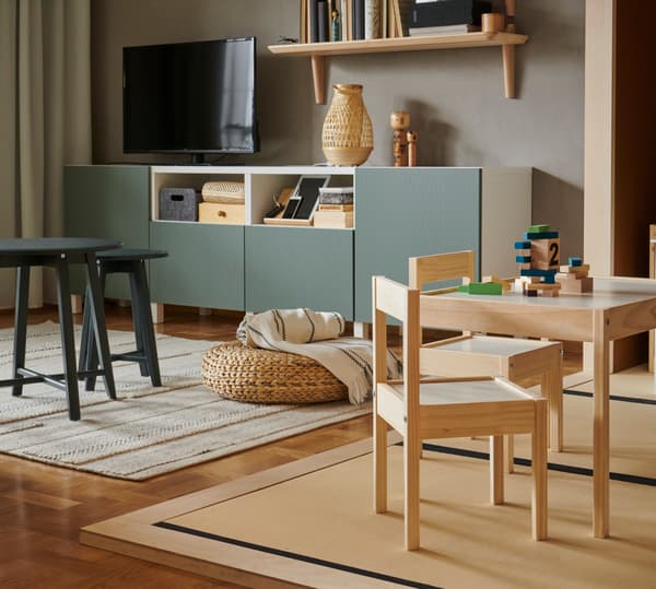 Living con mesas para niño a la derecha, y un mueble para tv a la izquierda.