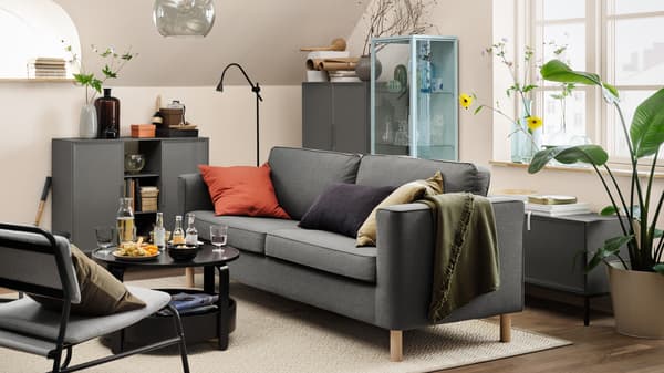 Living con un sofá gris, una silla gris y un mueble gris.