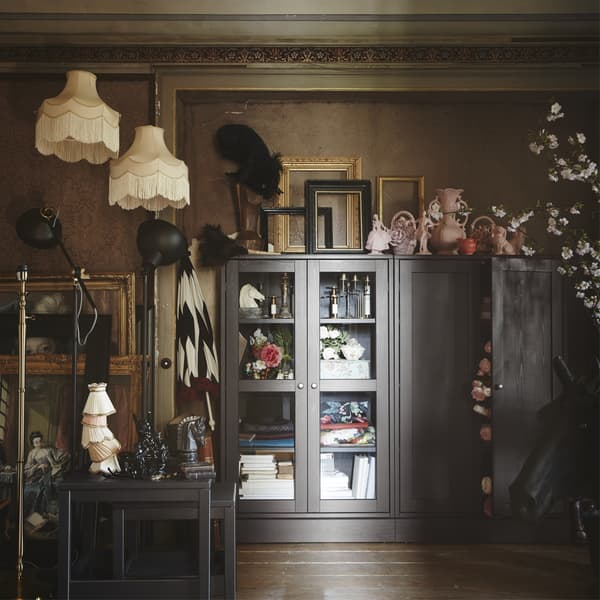 Living room full of lampshades, frames and a glass-front cabinet.