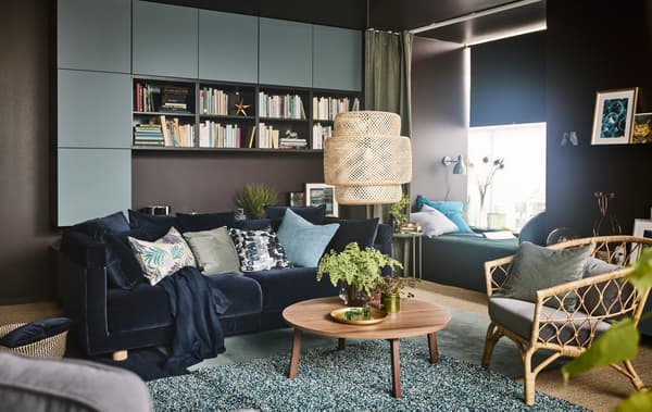Living room with blue and green as predominant colours. A blue velvet sofa dominates the image.