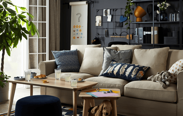 Living room with sofa and coffee table, with an ongoing origami-folding and drinks-and-snacks session.