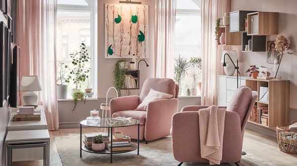 Living room with two EKOLSUND recliners in GUNNARED light brown-pink covers, in front of windows with light streaming in.