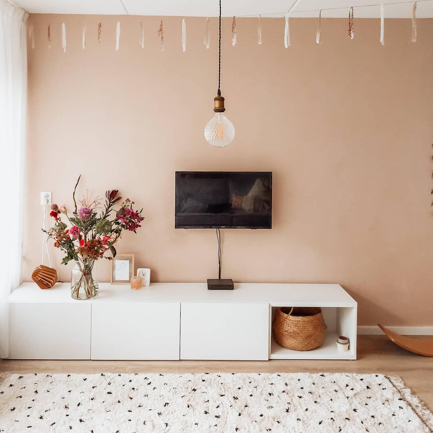 livingroom area, pink wall and white cabinets 