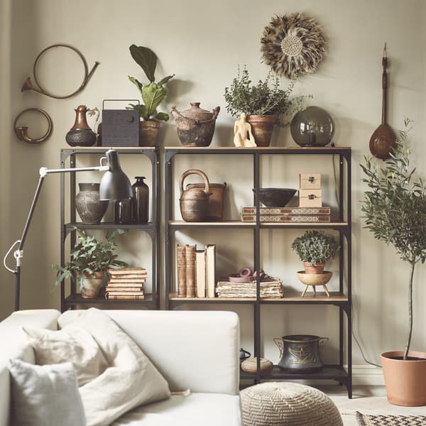 Livres, cache-pots et plantes exposés sur une étagère en bois et en métal, dans un séjour.