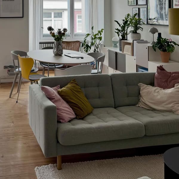 Ljusgrå LANDSKRONA tygsoffa stårnde i rum med öppen planlölsning. 