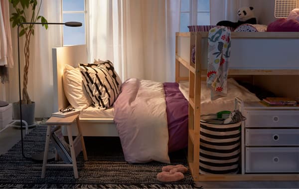 Llit alt amb un llit inferior, com el d'un nen que es col·loca entre els pares, en una habitació amb poc espai.