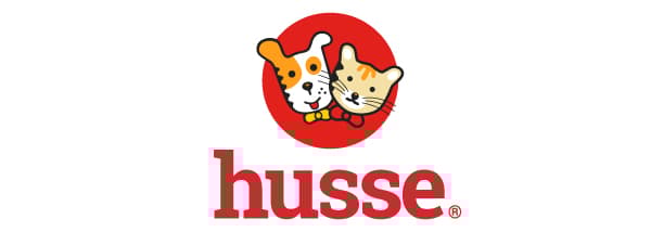 Logo-ul Husse prezintă un câine alb cu pete portocalii și un pisoi portocaliu, amândoi purtând papioane roșii, pe un fundal roșu circular. Sub imagine este scris cuvântul 