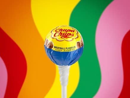 Lolli vor bunten Schlangenlinien