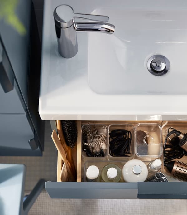 Looking for big storage in a small bathroom? One tip is to use drawer organisers to keep small things in check.