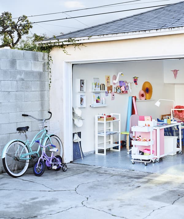 Looking into a colorful home office in a garage from the concrete driveway.