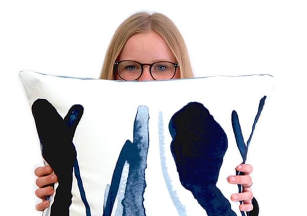 Lorena of Ellas lo Bordan holding a cushion from the ÅTERSTÄLLA collection