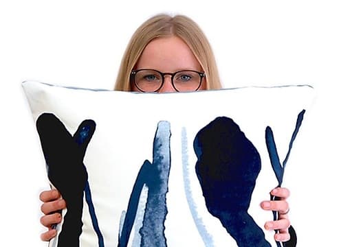 Lorena of Ellas lo Bordan holding a cushion from the ÅTERSTÄLLA collection