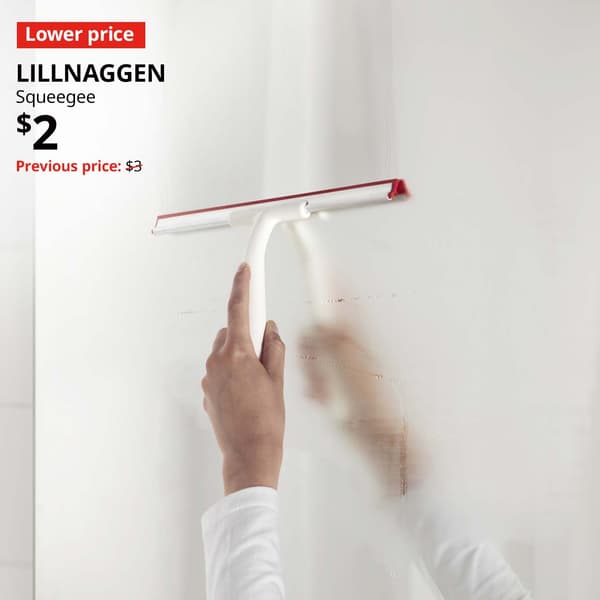 Lower price tag. Hand holding a LILLNAGGEN squeegee and using it across a glass surface for cleaning. $2