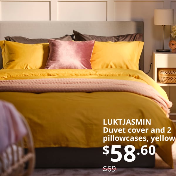 LUKTJASMIN duvet cover and 2 pillowcases, yellow, 200x200/50x80 cm, placed on a bed in a bedroom. Offer price: $58.60. Usual price: $69. 