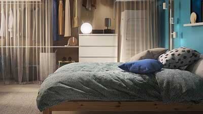 Luminosa camera da letto con un sommier FINNSNES grigio, biancheria colorata e grande guardaroba PAX/FORSAND.