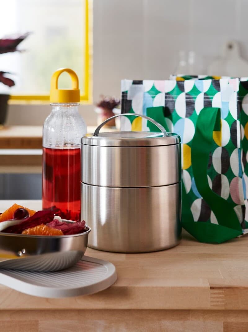 Lunch boxes
Stainless steel lunch boxes placed on a wooden kitchen counter next to a bottle of juice and a green patterned lunch bag.