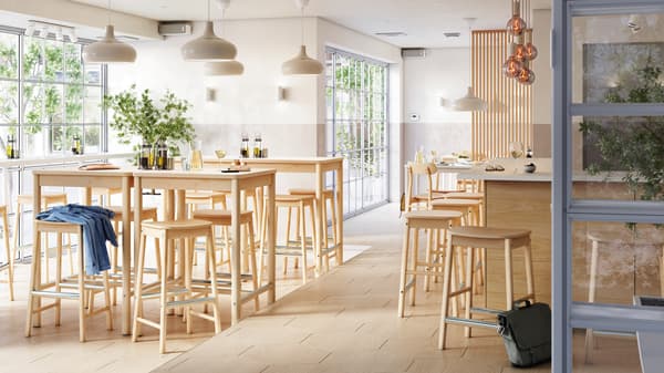 Lys og luftig bar med flere soner, RÖNNINGE barkrakker og bord ved et vindu og barkrakker ved en bardisk i midten.