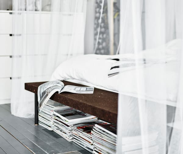 Magazines empilés sous un banc en liège, à l’extrémité du lit. Quelle est votre chambre à coucher idéale?
