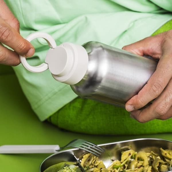 main faisant le geste d'ouvrir une gourde en métal