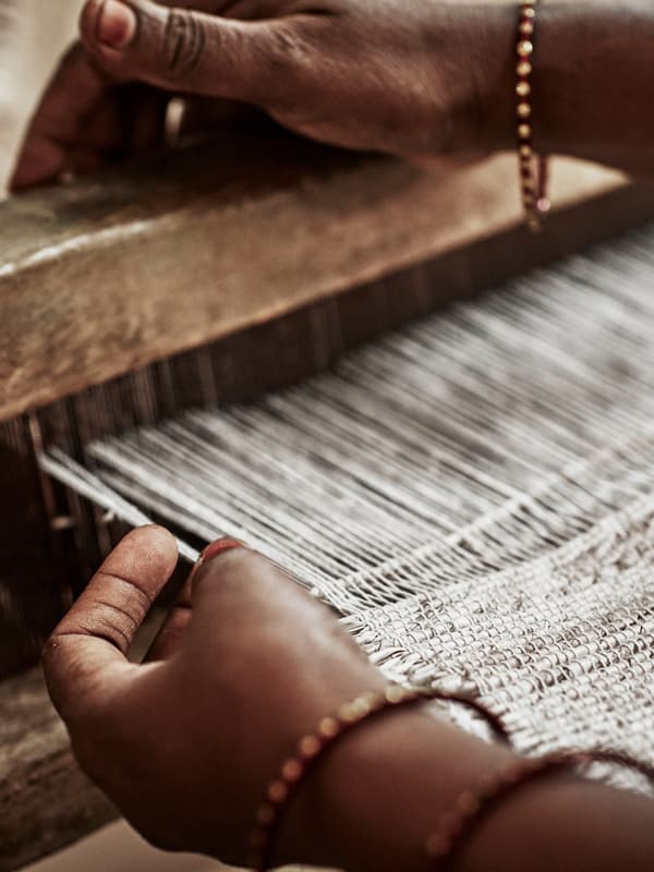 Mains d’une tisserande indienne en plein travail. Elle porte plusieurs bracelets en cuivre.
