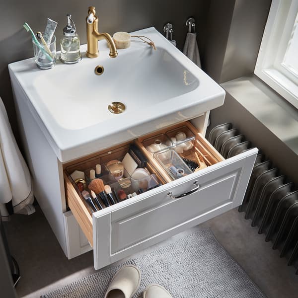 Makeup, hair tools and beauty tools are nicely organised in smoke-coloured see-through boxes that are in a wash stand drawer.