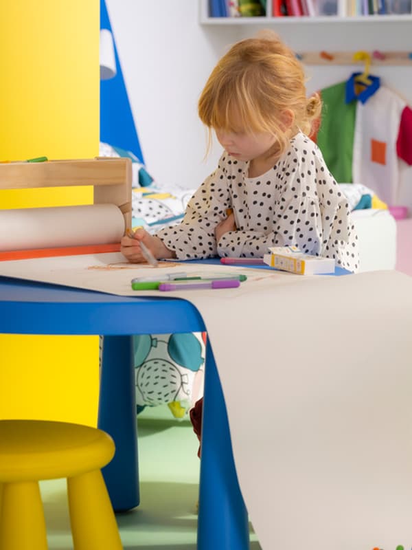 Malá holčička kreslí u stolu MAMMUT.