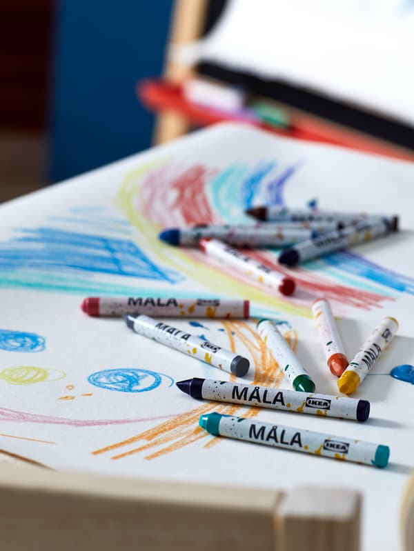 MÅLA zsírkréták hevernek egy telirajzolt papíron.