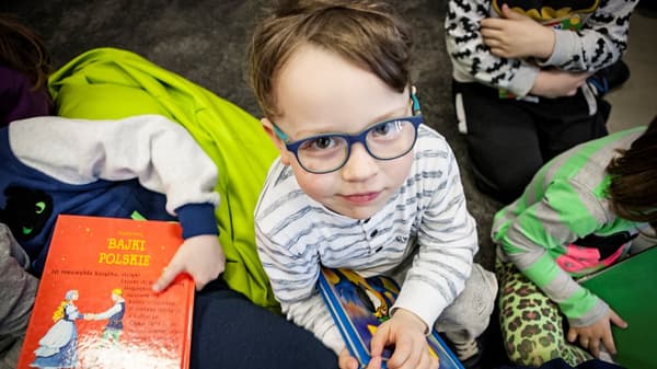 małe dziecko w szkole Elbląga czyta książkę