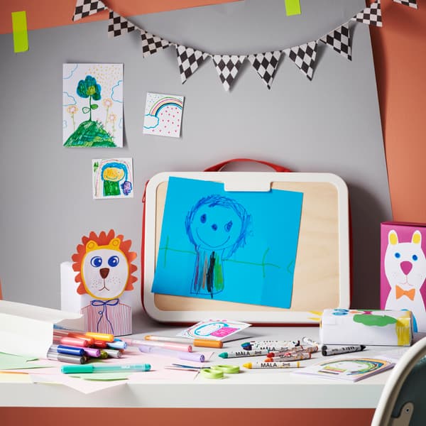 Maletín para dibujar con lápices de colores en una mesa blanca.
