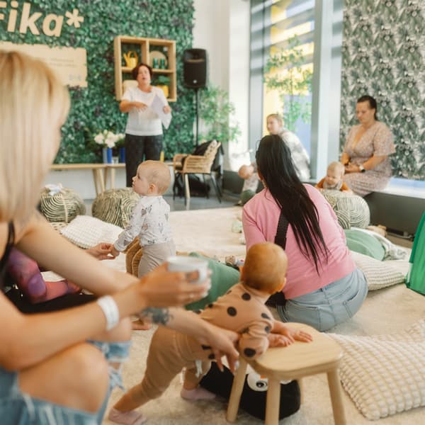 Māmiņas ar mazuļiem Vecāku rītiem īpaši iekārtotā stūrītī Zviedru restorānā lūkojas uz nodarbības vadītāju. Telpa gaišos koka un smilškrāsas toņos.