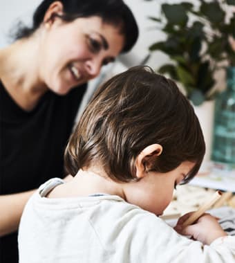 Mamma e bambino scrivono delle etichette per le piante.