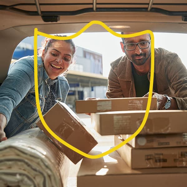Man and woman packing shopping into a car.