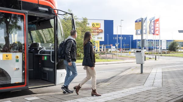 man and woman stepping off a bus at IKEA.
