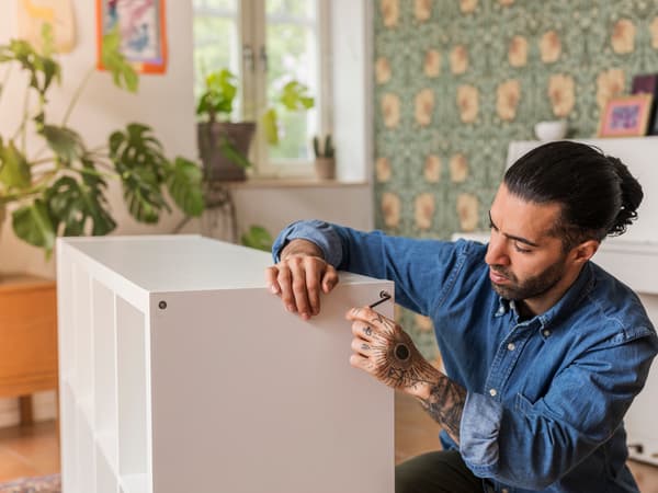 Man assembling white IKEA cabinet 