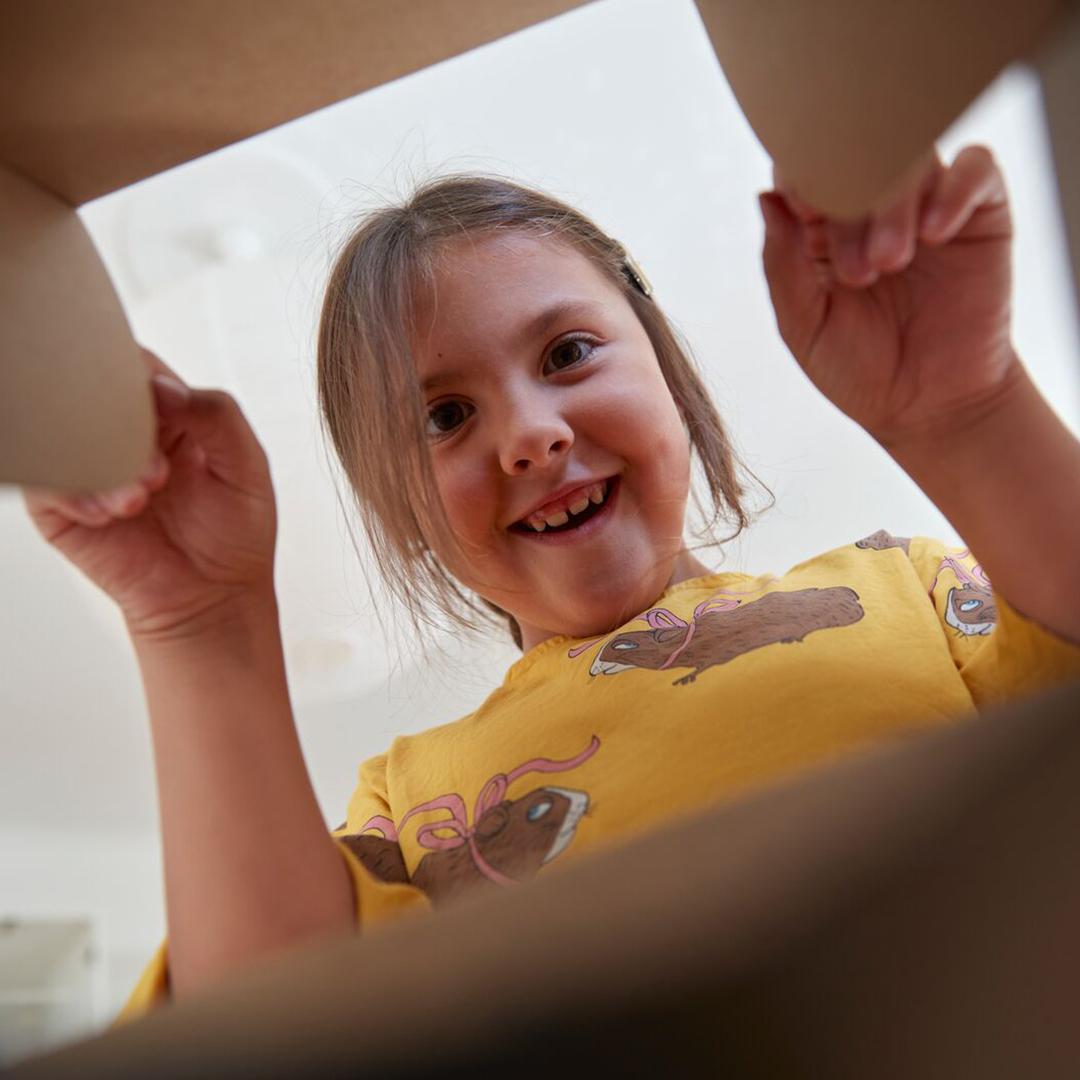 Man befindet sich in einem Karton und man sieht wie ein Kind reinschaut