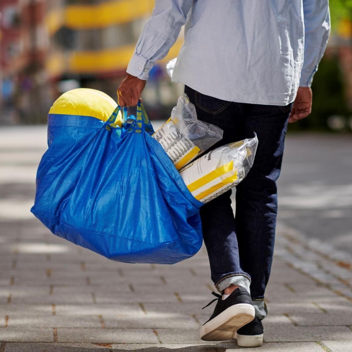 Man carrying a blue shopping bag
