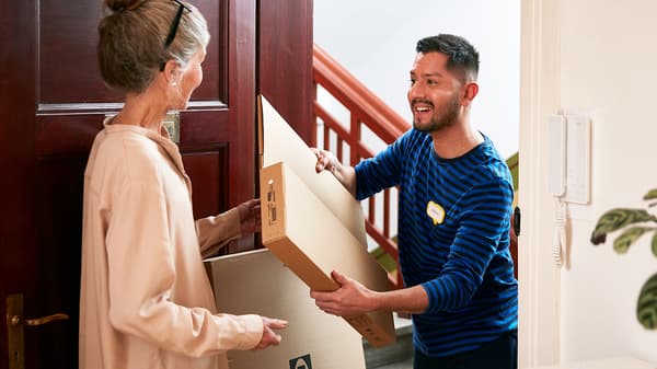 Man delivering an IKEA package to a woman at her front door
