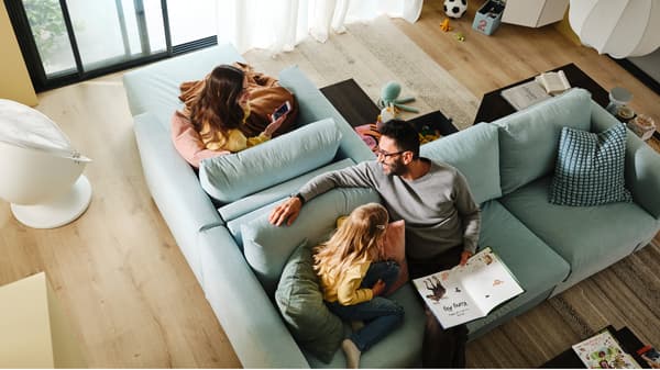 Man en kind zitten op een VIMLE 3-zitsslaapbank die rug tegen rug staat met een VIMLE chaise longue waar een vrouw op zit.